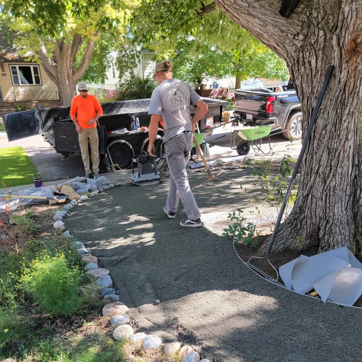 Indy crew preparing a stone-edged path beside a turf installation