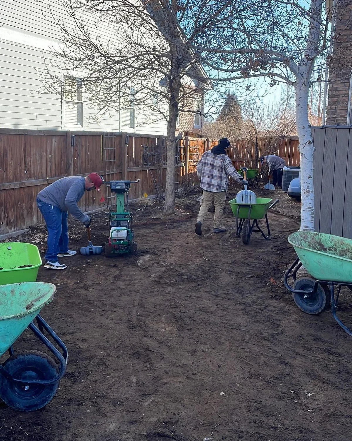 Indy crew preparing and compacting the ground for a backyard turf installation
